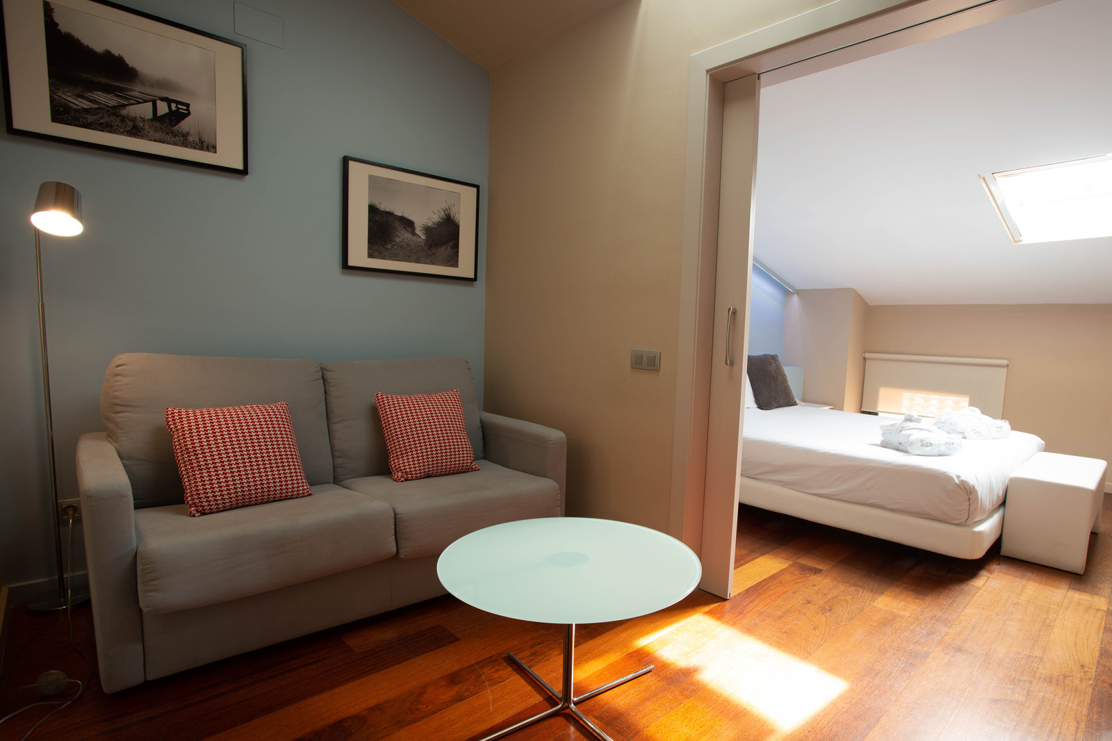Hotel suite with a sofa and a view through to the bedroom