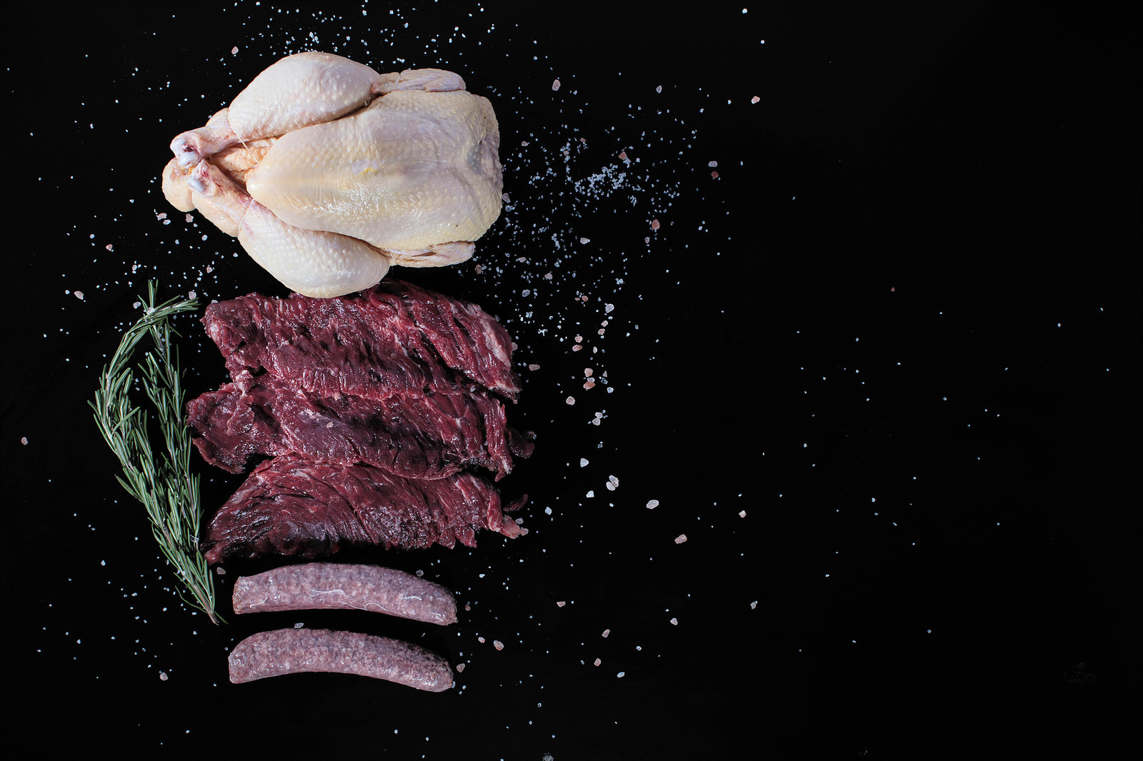 Meat and garlic arranged against a dark background