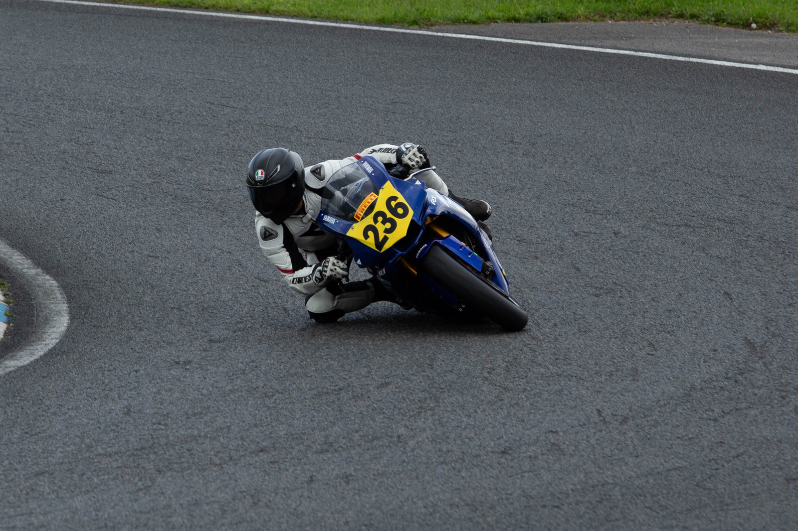 Motorcycle racer leaning into a corner on a racing circuit