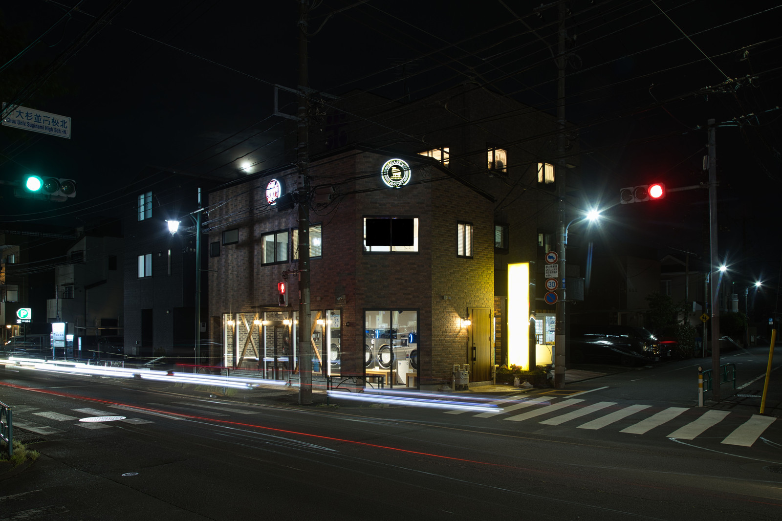 Illuminated building and street crossing photographed at night